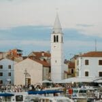 Chorwacki port o zmierzchu z łodziami i wieżą zegarową nad zatoką