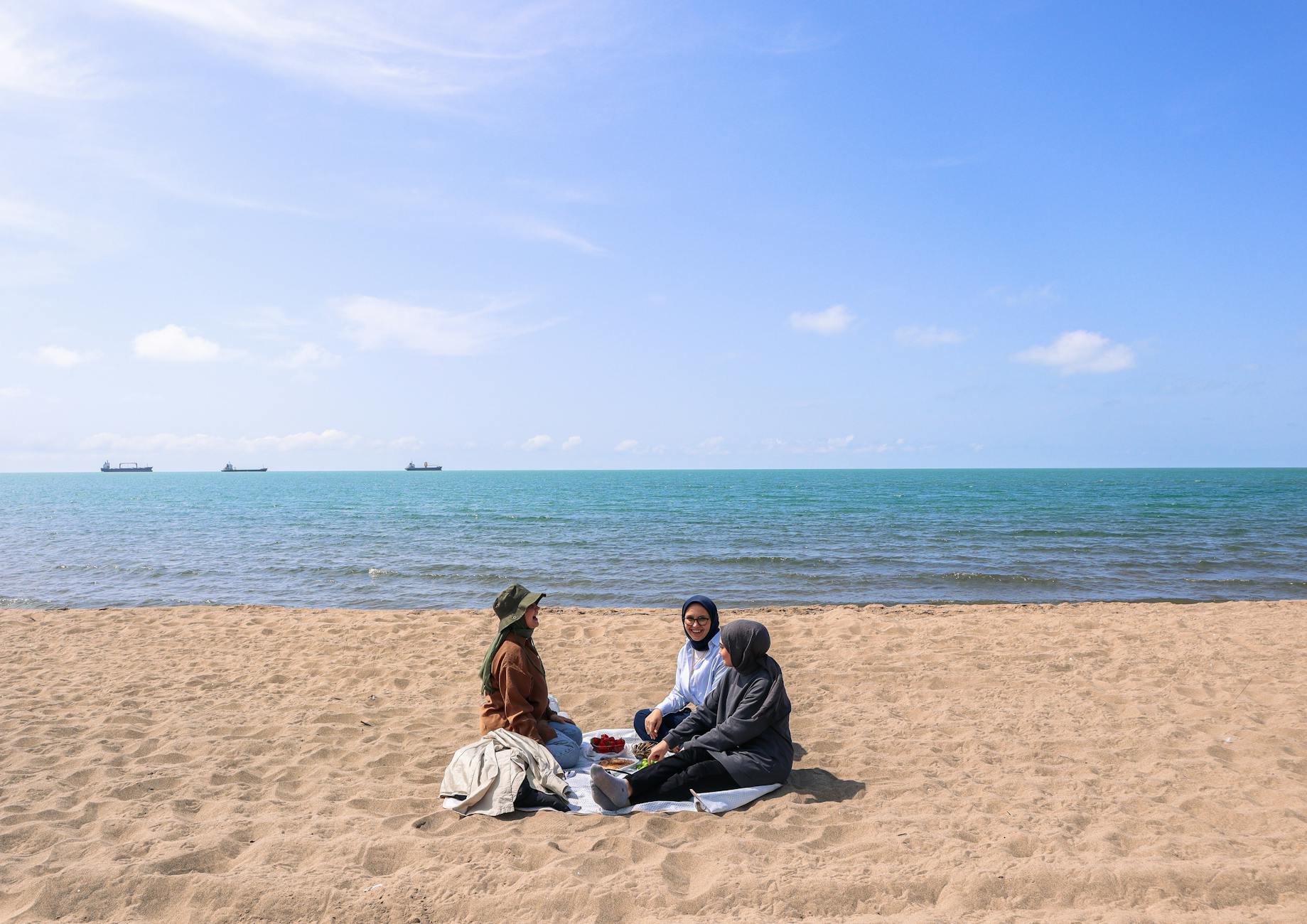 Trzy kobiety na pikniku na słonecznej plaży nad morzem