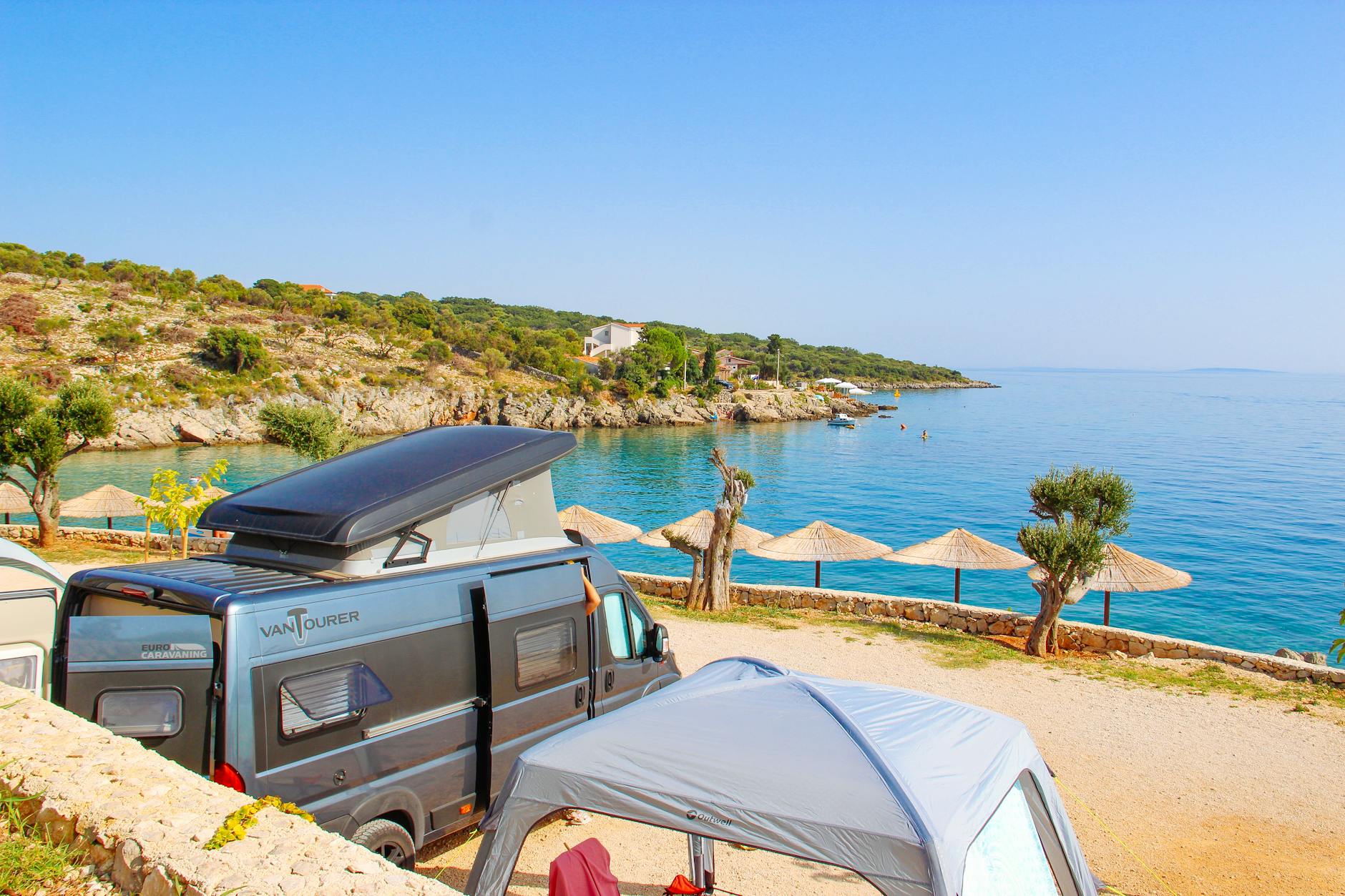 Kamper zaparkowany przy spokojnej plaży nad Adriatykiem w Novalji