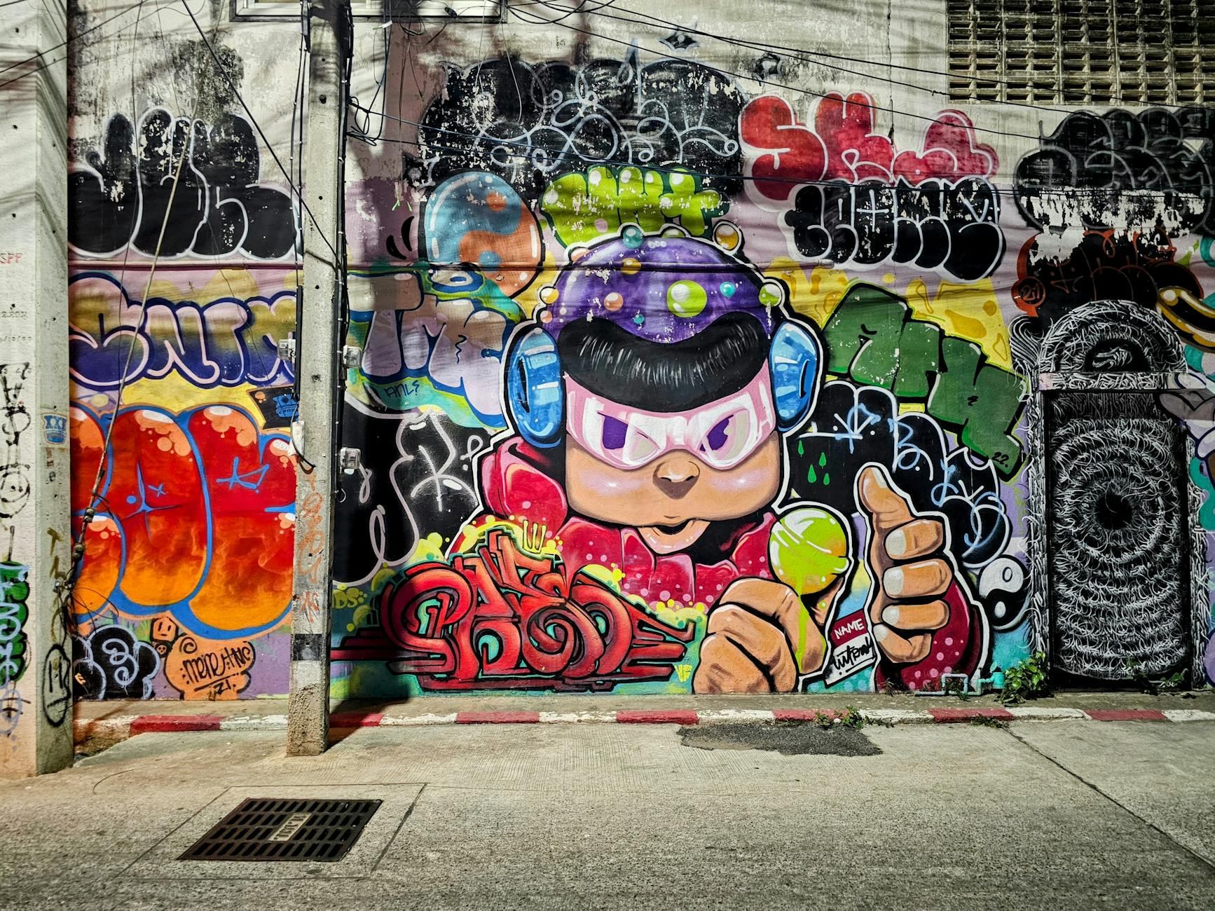 Kolorowe graffiti na ścianie w miejskiej uliczce przedstawiające sztukę uliczną
