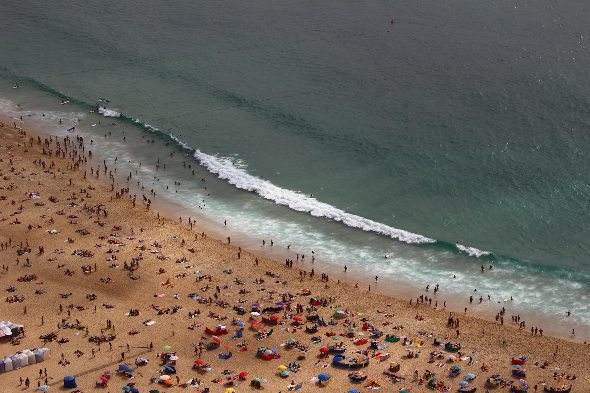 Tłoczna chorwacka plaża pełna turystów nad turkusowym morzem