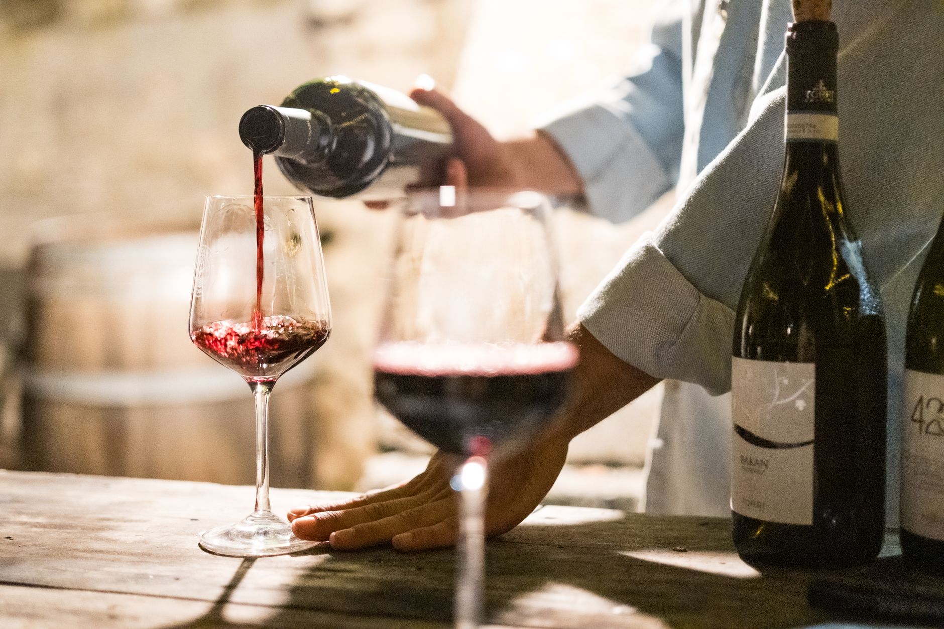 Nalewanie czerwonego wina do kieliszka w przytulnym chorwackim wine barze