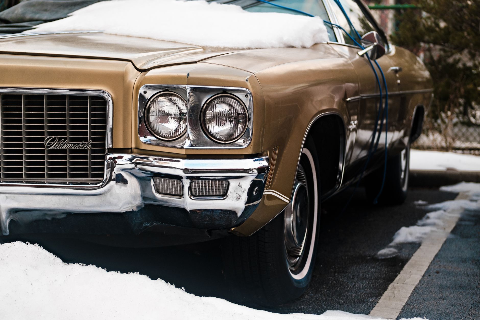 Zabytkowy samochód Oldsmobile zasypany śniegiem na zimowym parkingu Zabytkowy samochód Oldsmobile zasypany śniegiem na zimowym parkingu